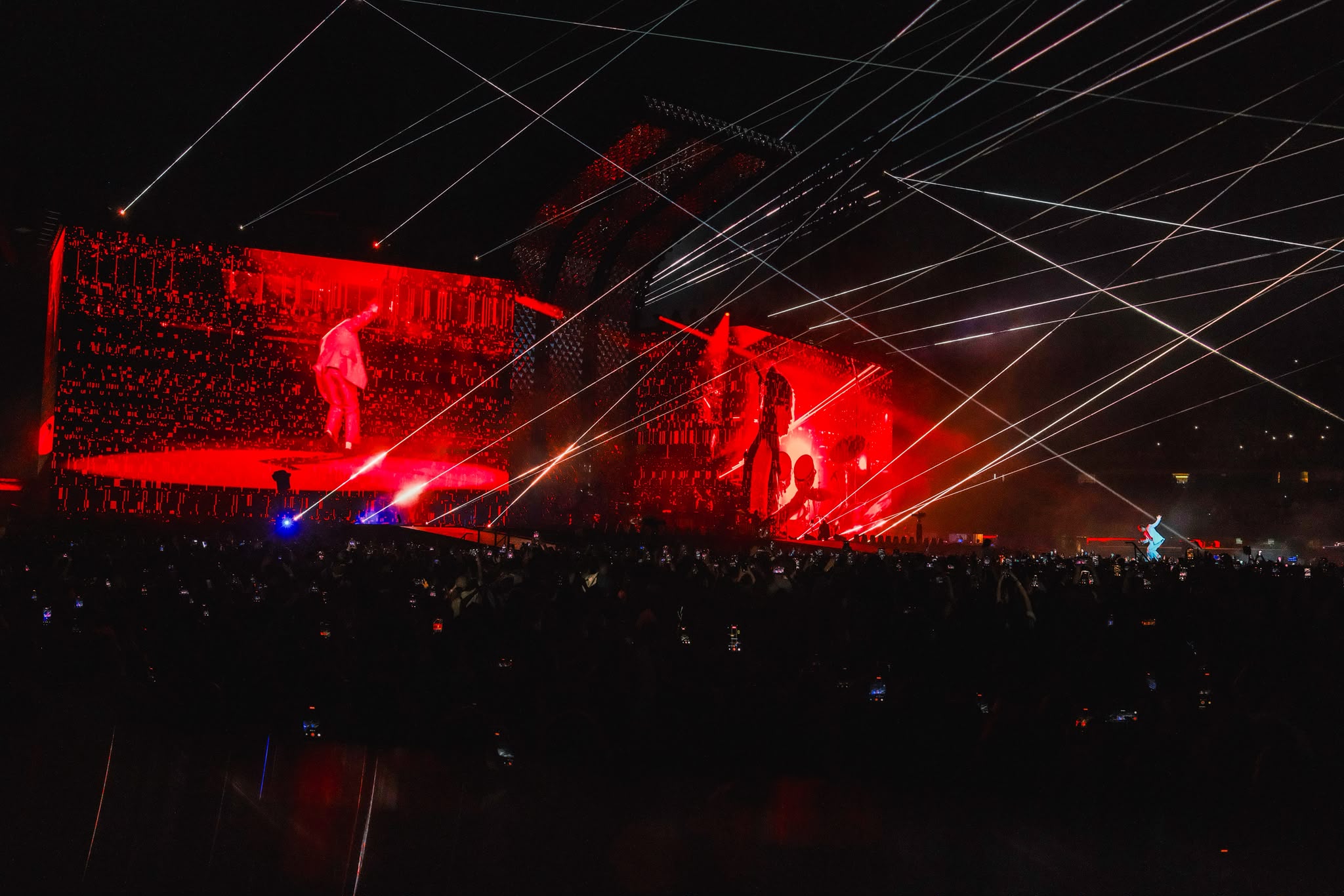 Red arena stage cut through with white laser beams
