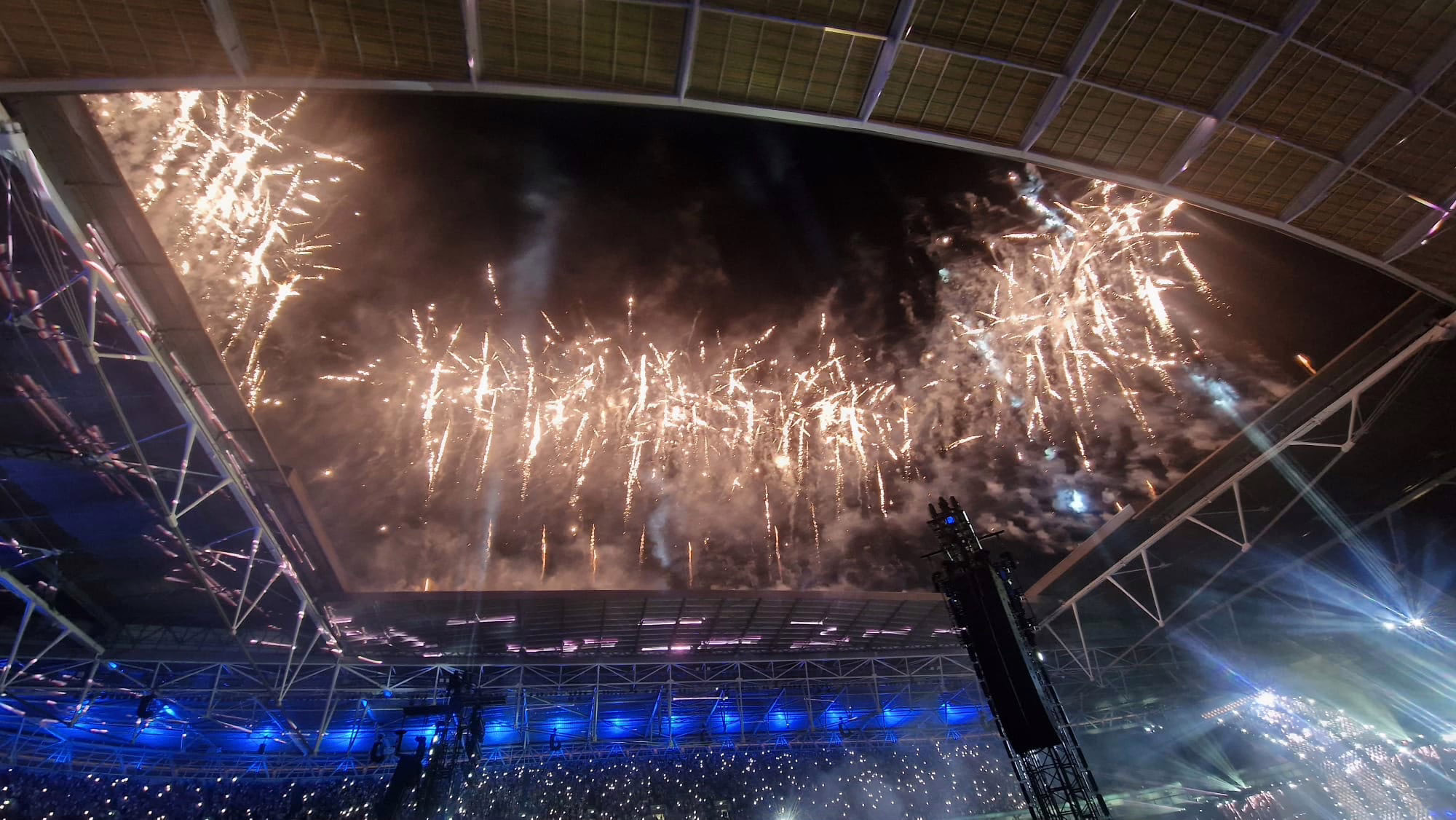 Stadium roof framed by a large-scale pyrotechnic display
